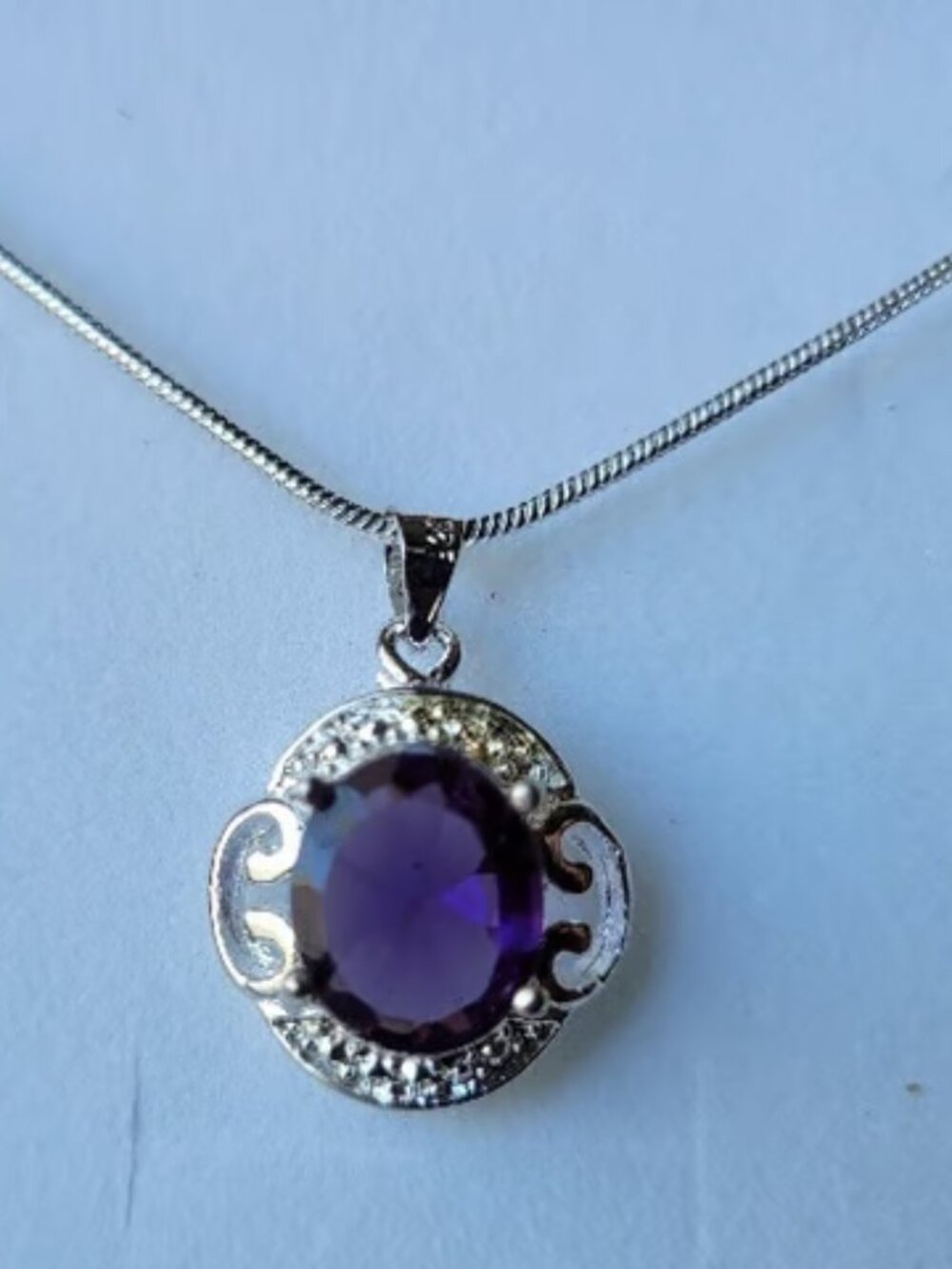 This exquisite necklace features a stunning purple stone set in a delicate silve